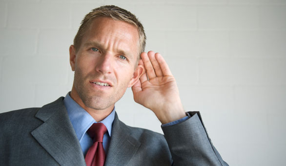 man cupping his ear